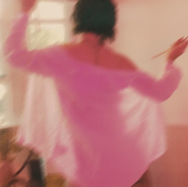 An expressive moment in a flowing pink shirt